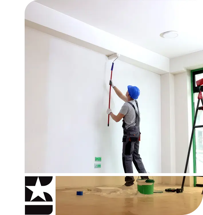 Professional painter applying premium white paint to a high interior wall for a residential renovation project in Somerville, MA.